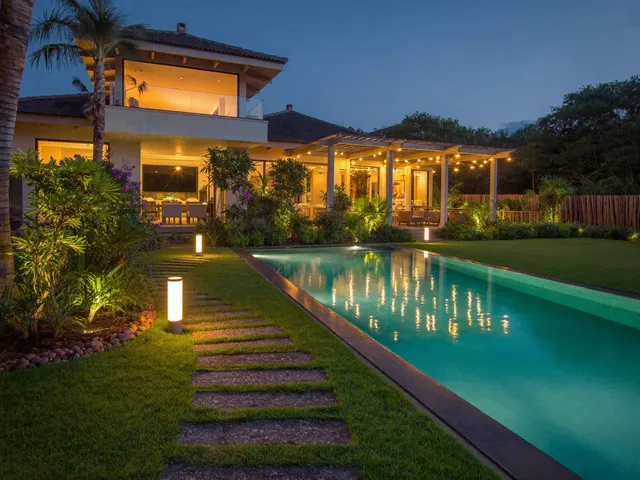 Warm garden and pool lighting of a Bali villa at dusk